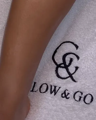 Geborduurd Glow & Go-logo op een handdoek in de salon
